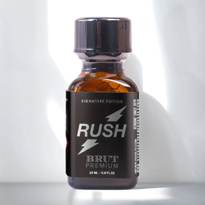 Rush Brut Premium Poppers 24ml featuring lightning bolt graphics and containing 24 ml (0.8 fl. oz) of liquid is set against a white background with subtle light reflections.